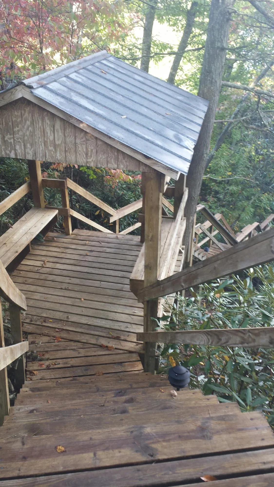 Metal roofed shelter over wooden steps on a wooded walkway — Skylight Repair & Installation work by our crew in Whiting
