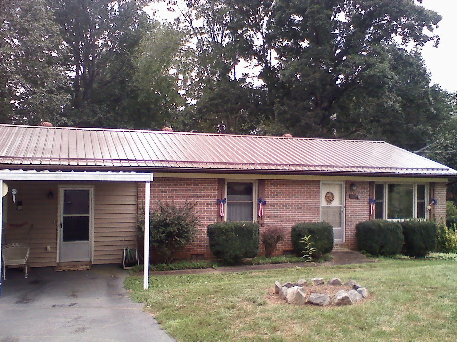 Bronze metal roof and carport on a brick ranch home — Roof Repair work by our crew in Whiting